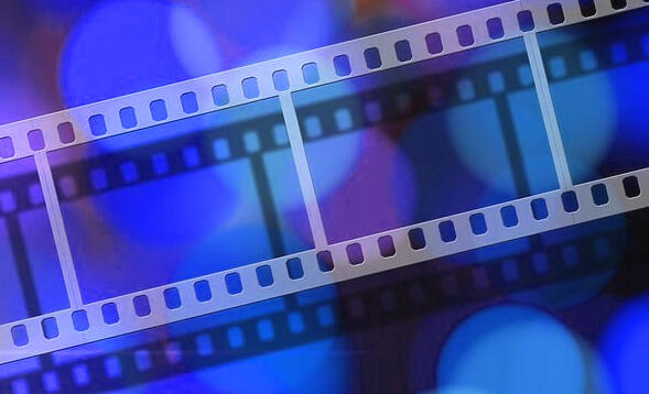 Close-up of a film reel with deep blue and plum bokeh behind it